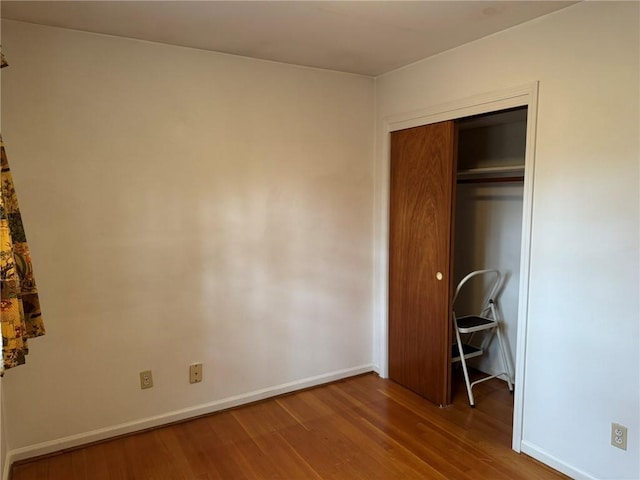 unfurnished bedroom featuring hardwood / wood-style floors and a closet