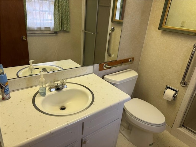 bathroom featuring vanity, toilet, and a shower with door