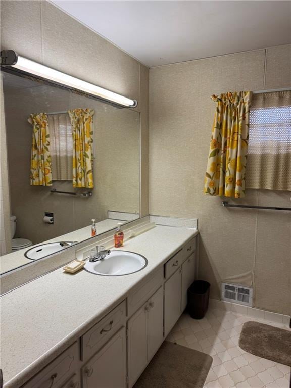 bathroom with vanity, toilet, and tile patterned flooring