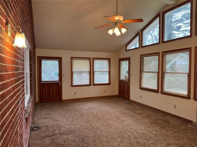 unfurnished living room with high vaulted ceiling, ceiling fan, and carpet