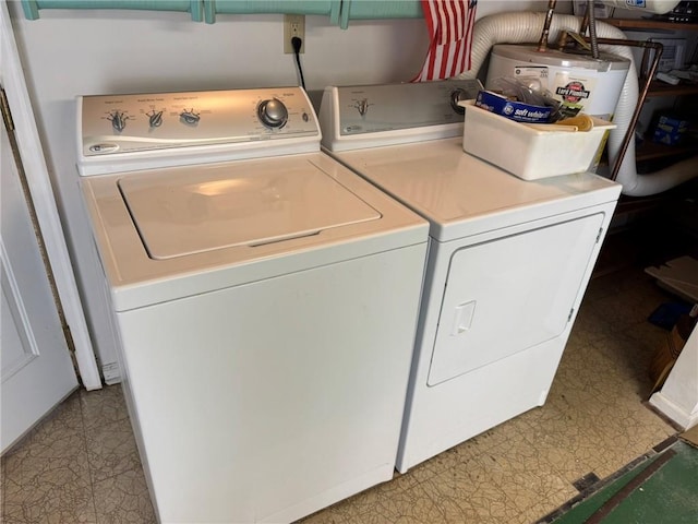 clothes washing area with washing machine and dryer and water heater