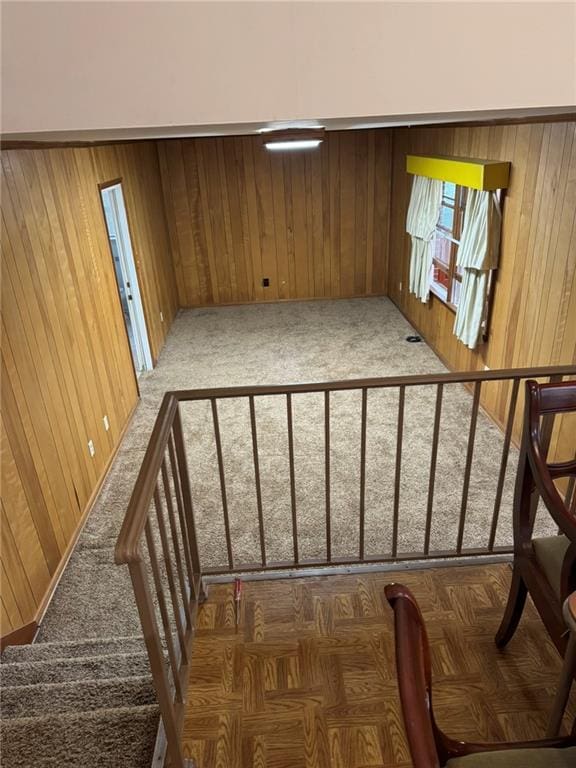 stairs featuring carpet flooring and wood walls