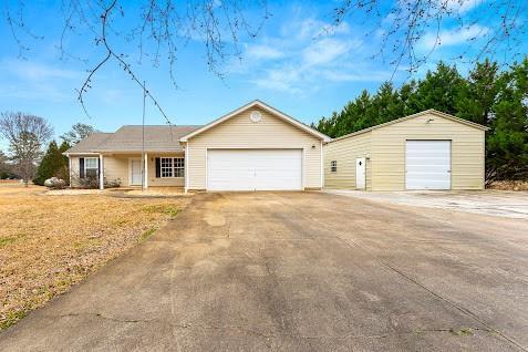 ranch-style home with a garage and an outbuilding