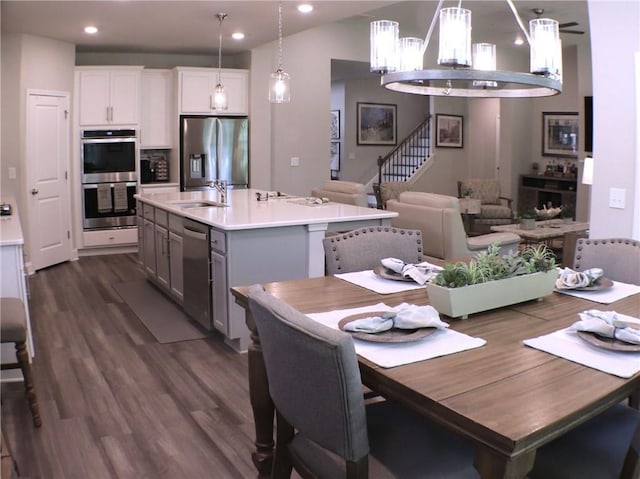 dining space with recessed lighting, an inviting chandelier, stairway, and dark wood-type flooring