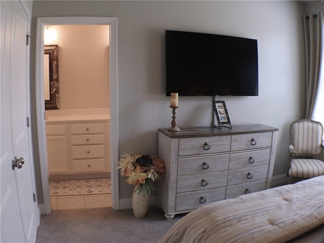 tiled bedroom featuring baseboards, carpet flooring, and connected bathroom