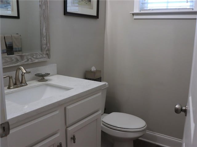 half bathroom featuring vanity and toilet