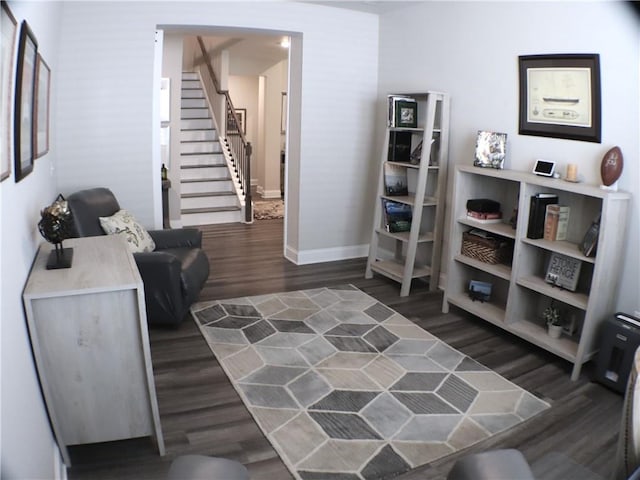 sitting room featuring stairs, baseboards, and dark wood-style floors