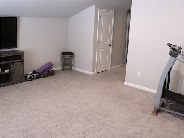 exercise area featuring baseboards and carpet flooring