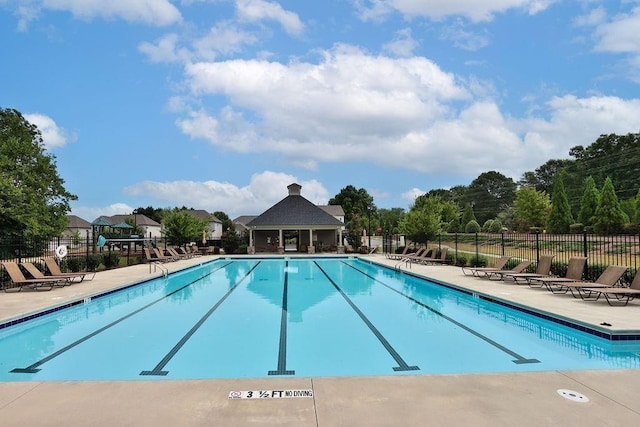 community pool with fence and a patio