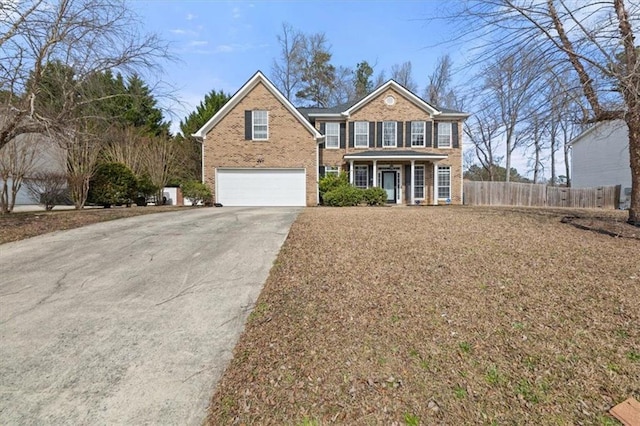 view of front of home with a porch, an attached garage, brick siding, fence, and driveway