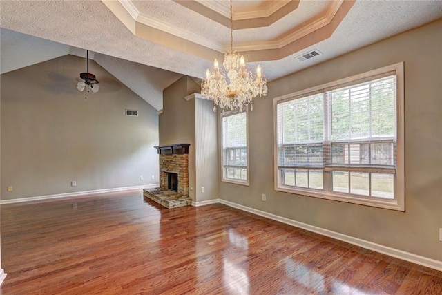 unfurnished living room featuring visible vents, a healthy amount of sunlight, a raised ceiling, and wood finished floors
