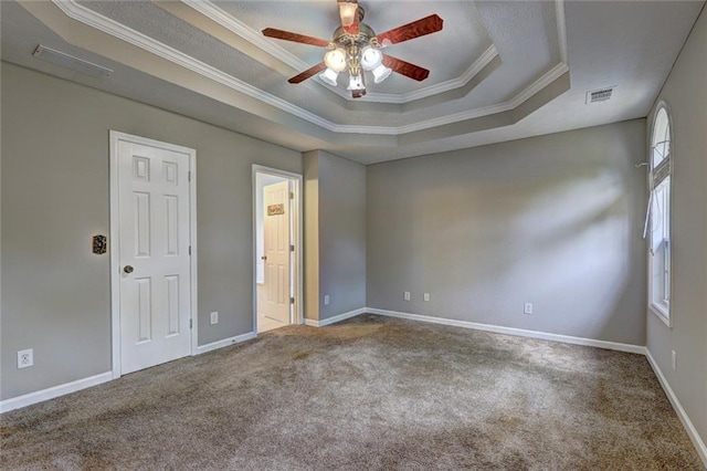 unfurnished room with visible vents, crown molding, ceiling fan, a tray ceiling, and carpet flooring