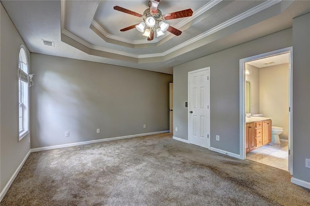 unfurnished bedroom featuring visible vents, light carpet, ornamental molding, and a raised ceiling