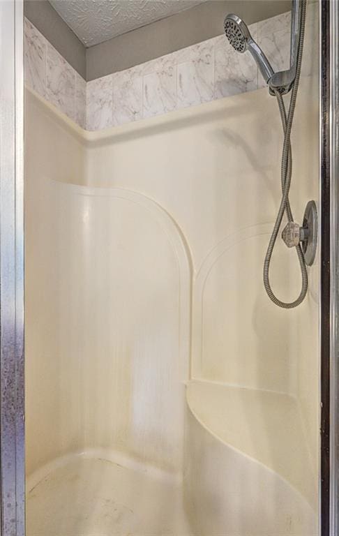 bathroom featuring a textured ceiling and walk in shower