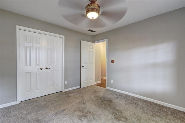 unfurnished bedroom with visible vents, a ceiling fan, a closet, baseboards, and carpet flooring