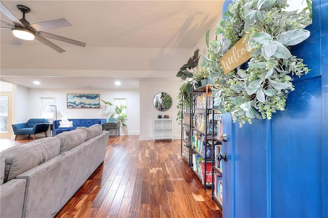 living area featuring hardwood / wood-style floors, baseboards, and ceiling fan