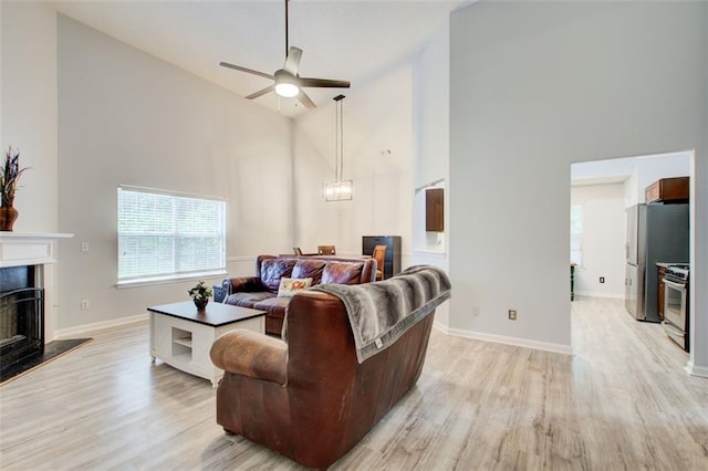 468 Berkshire Pl, Fairburn, GA 30213 - living area with high vaulted ceiling, ceiling fan, light wood finished floors, a chandelier, and a premium fireplace
