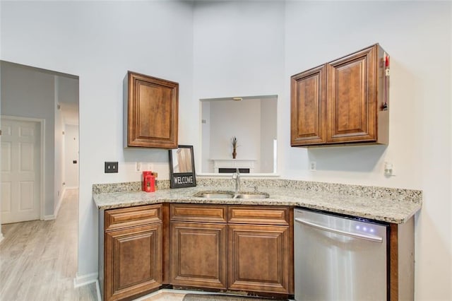 468 Berkshire Pl, Fairburn, GA 30213 - kitchen featuring stainless steel dishwasher, a sink, brown cabinets, light stone counters, and a towering ceiling