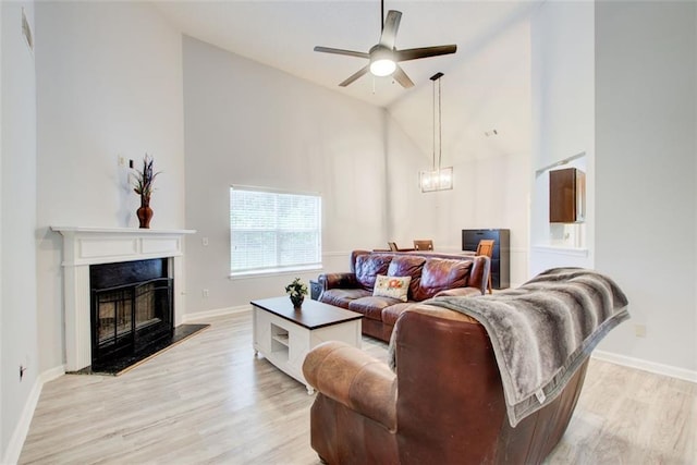468 Berkshire Pl, Fairburn, GA 30213 - living area featuring high vaulted ceiling, light wood finished floors, a premium fireplace, a ceiling fan, and baseboards