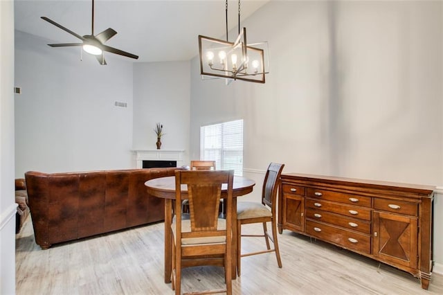 468 Berkshire Pl, Fairburn, GA 30213 - dining space featuring a fireplace, light wood-style floors, ceiling fan, and a chandelier