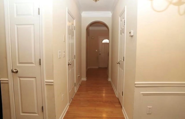 corridor featuring light wood-type flooring and crown molding