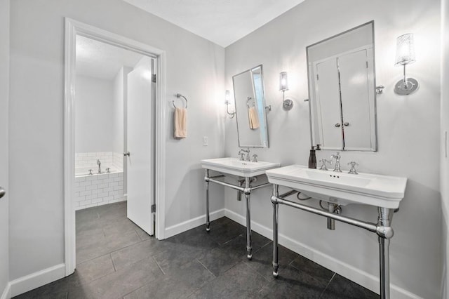 bathroom featuring tiled tub, dual sinks, and tile patterned floors