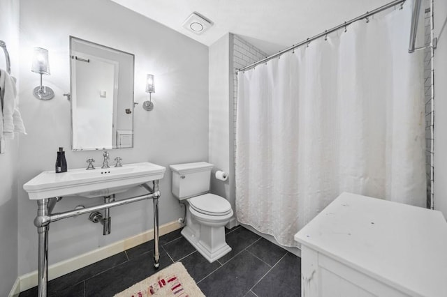 bathroom with sink, curtained shower, tile patterned floors, and toilet