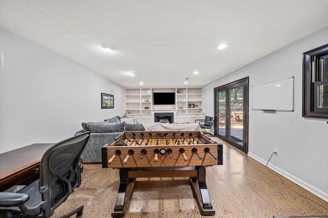 recreation room featuring french doors and built in shelves