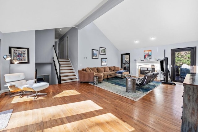 living room with wood-type flooring, high vaulted ceiling, and beamed ceiling