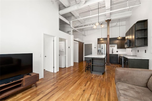 210 Walker St SW Unit 3, Atlanta, GA 30313 - kitchen with open shelves, a towering ceiling, open floor plan, a breakfast bar, and light countertops
