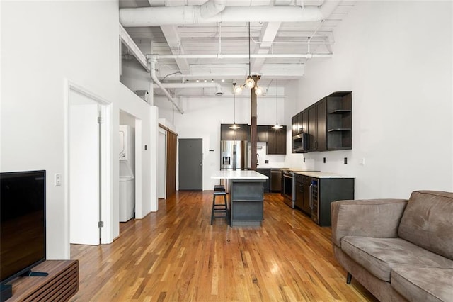 210 Walker St SW Unit 3, Atlanta, GA 30313 - kitchen with open shelves, stainless steel appliances, a high ceiling, a kitchen bar, and light wood-type flooring