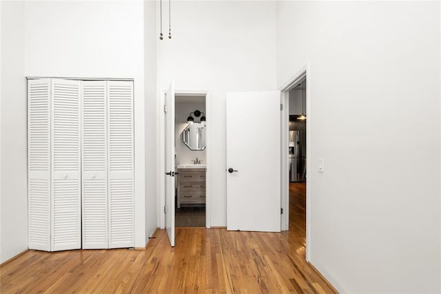 210 Walker St SW Unit 3, Atlanta, GA 30313 - unfurnished bedroom featuring a high ceiling, light wood finished floors, a closet, stainless steel fridge with ice dispenser, and ensuite bathroom
