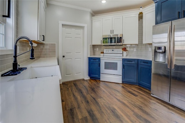 kitchen with dark wood-style floors, appliances with stainless steel finishes, ornamental molding, blue cabinets, and a sink