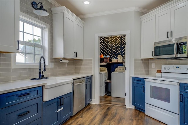 kitchen with white cabinets, blue cabinetry, washing machine and dryer, and stainless steel appliances