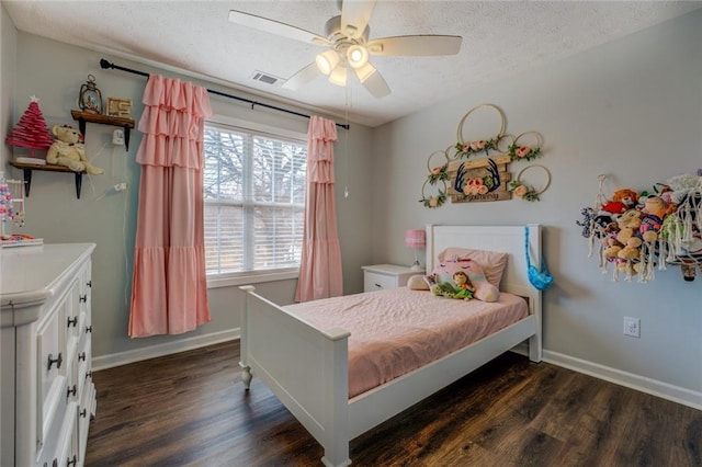 bedroom featuring dark wood-style floors, a textured ceiling, visible vents, and baseboards