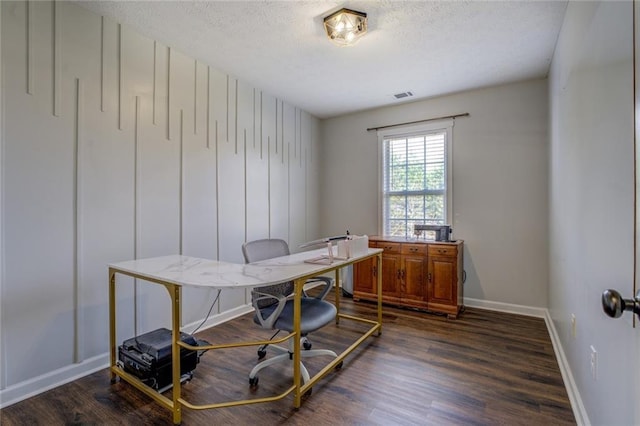 office area with baseboards, a textured ceiling, visible vents, and dark wood-type flooring