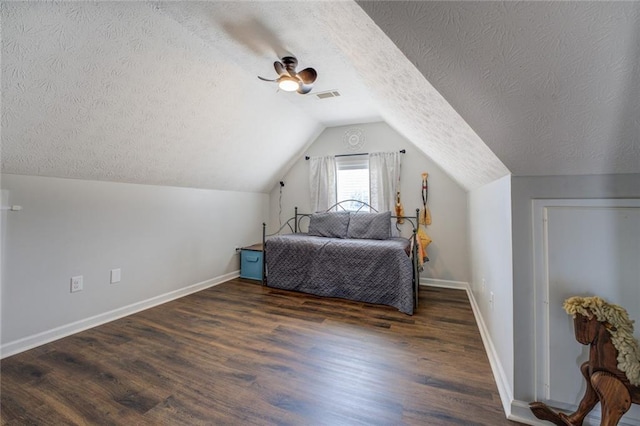 bedroom with lofted ceiling, wood finished floors, visible vents, and baseboards