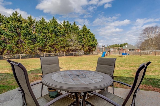 view of patio / terrace with a fenced backyard, a playground, and outdoor dining space