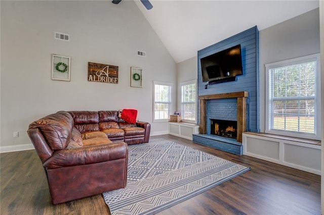 living room featuring a fireplace, visible vents, and wood finished floors