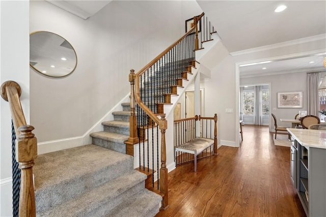 stairway featuring ornamental molding, recessed lighting, wood finished floors, and baseboards