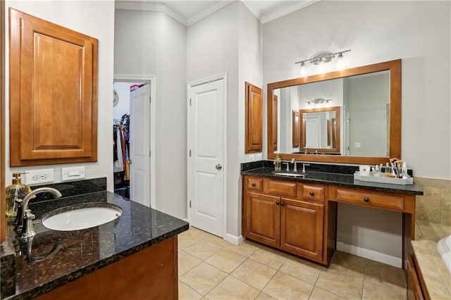 bathroom featuring a bathing tub, tile patterned flooring, ornamental molding, and vanity