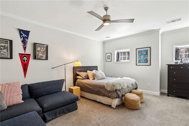 carpeted bedroom featuring ceiling fan, ornamental molding, visible vents, and baseboards