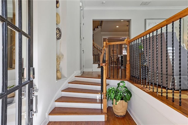 interior space with baseboards, crown molding, and wood finished floors