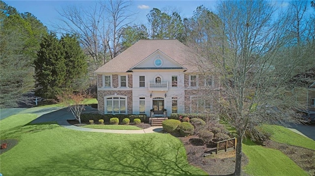 view of front of house featuring a front lawn and a balcony