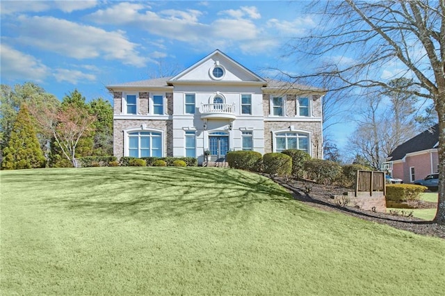 view of front of house featuring a front lawn and a balcony