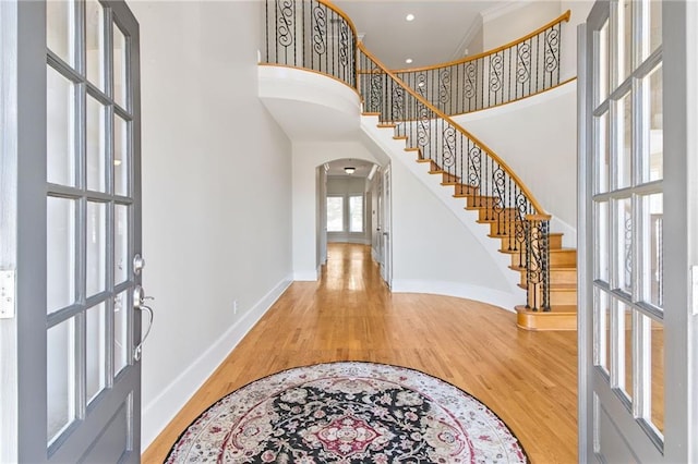 foyer with a towering ceiling and hardwood / wood-style floors