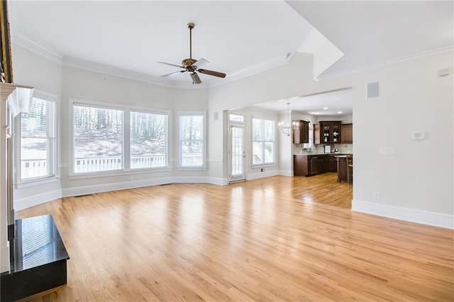 unfurnished living room with ornamental molding, ceiling fan, and light hardwood / wood-style flooring