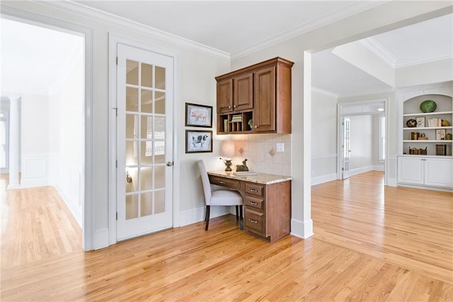 bar with ornamental molding, built in features, light hardwood / wood-style floors, and decorative backsplash