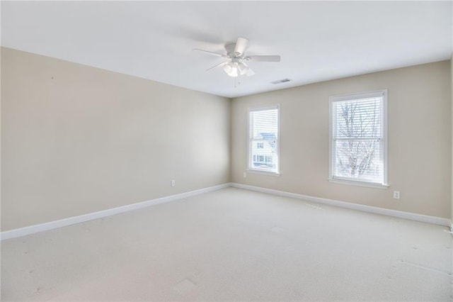 carpeted spare room featuring ceiling fan