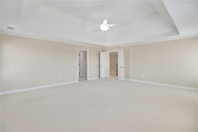 carpeted empty room featuring a tray ceiling and ceiling fan